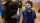A healthcare worker prepares to give a vaccine to a patient. Both people are wearing medical face masks.